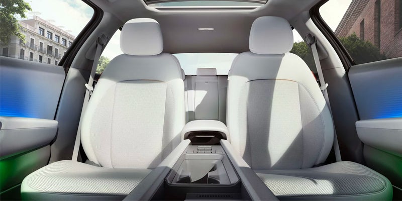 Interior of electric car showing white leather seats and center console
