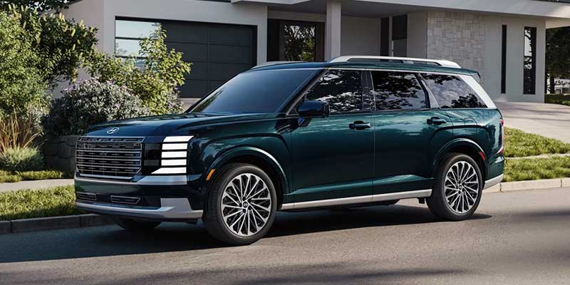 Side/front three-quarter view of the same dark green SUV parked on a residential street